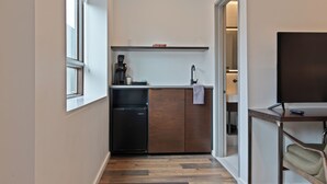A compact kitchen with a dishwasher, a coffee machine, and a small countertop.