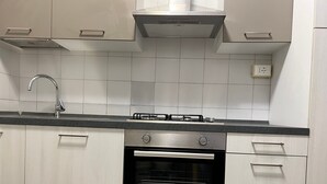 A kitchen with a stainless steel range hood, a built-in oven, and a modern faucet. - 'Venice' Apartment with Wi-Fi and Air Conditioning (Venezia)