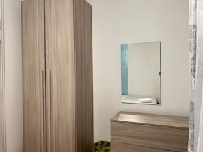 Une pièce comprenant une armoire, une commode et un miroir mural.