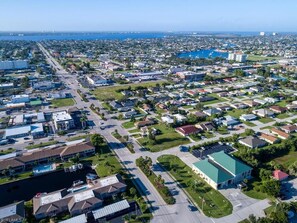 Luchtbeeld van een woongebied met huizen, straten en een groot wateroppervlak op de achtergrond.