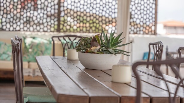 A wooden table with a bowl of plants and candles, surrounded by chairs. - Vacation Home 'La Era' with Mountain View, Private Pool and Wi-Fi (Adeje)