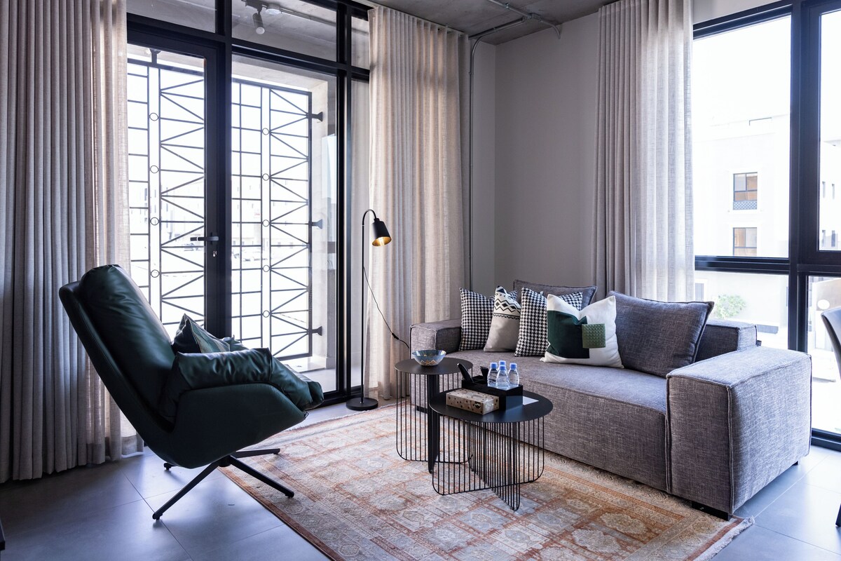 Un salon moderne avec un canapé, un fauteuil et une table basse.