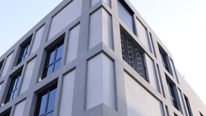 A modern building with a corner entrance, large windows, and a fire hydrant outside. - C LIVING 3 - ALMALQA (Riyadh)