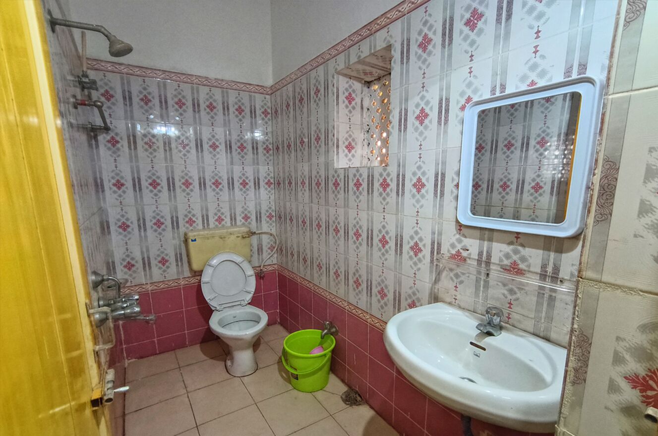 Un bagno con il water, lavandino e doccia.
