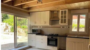 Una cocina con armarios blancos, estufa y microondas.