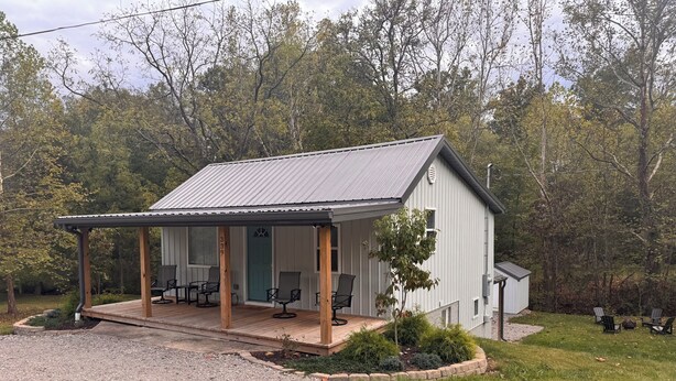 A single-story building with a covered porch, a green door, and a number '359' on the wall.