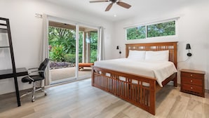 A bedroom with a wooden bed, a desk, and a chair.