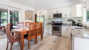 A modern kitchen with white cabinets, stainless steel appliances, and a granite countertop.