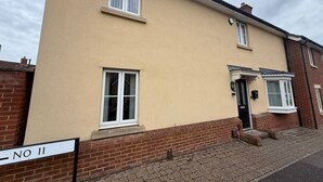 Un immeuble résidentiel de deux étages, doté d’une façade beige, de fondations en briques et d’une enseigne indiquant le numéro « 11 ».