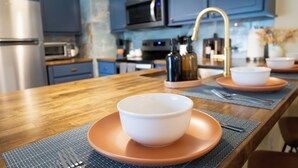 A modern kitchen with blue cabinets, stainless steel appliances, and a wooden countertop. - New Meets Nostalgic- Cottage Sleeps 8 (Savannah)