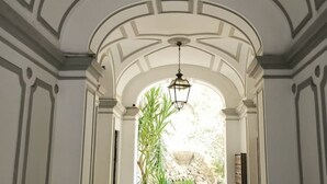 Un pasillo abovedado con un farol colgante y una pared de piedra al fondo.