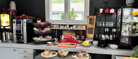 A kitchen area with a coffee machine, a refrigerator, and various food items displayed on the counter.