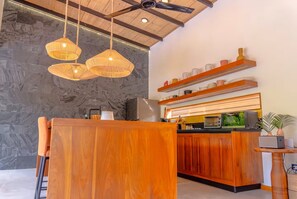 A modern kitchen with wooden cabinets, a built-in oven, and a countertop with various appliances.