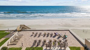 A beachside area with sun loungers and a staircase leading to a higher platform.