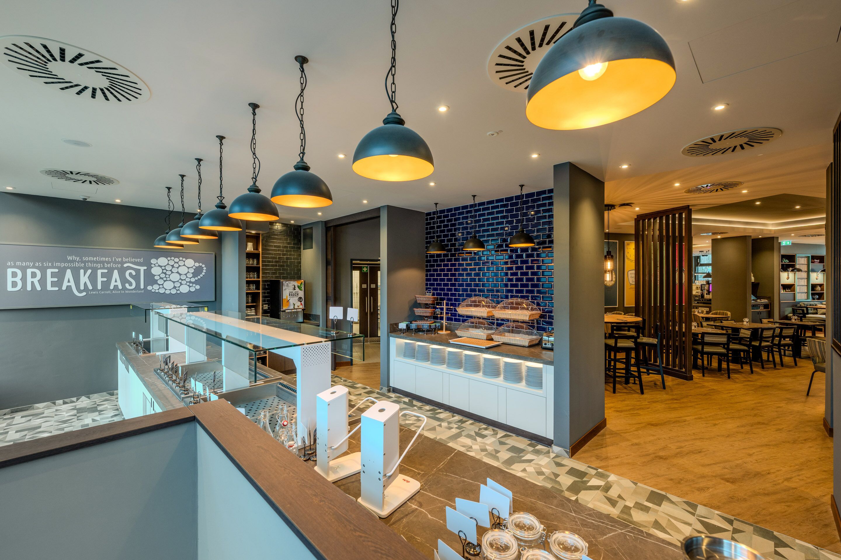 A modern breakfast area with a counter, seating, and a sign reading 'BREAKFAST'.