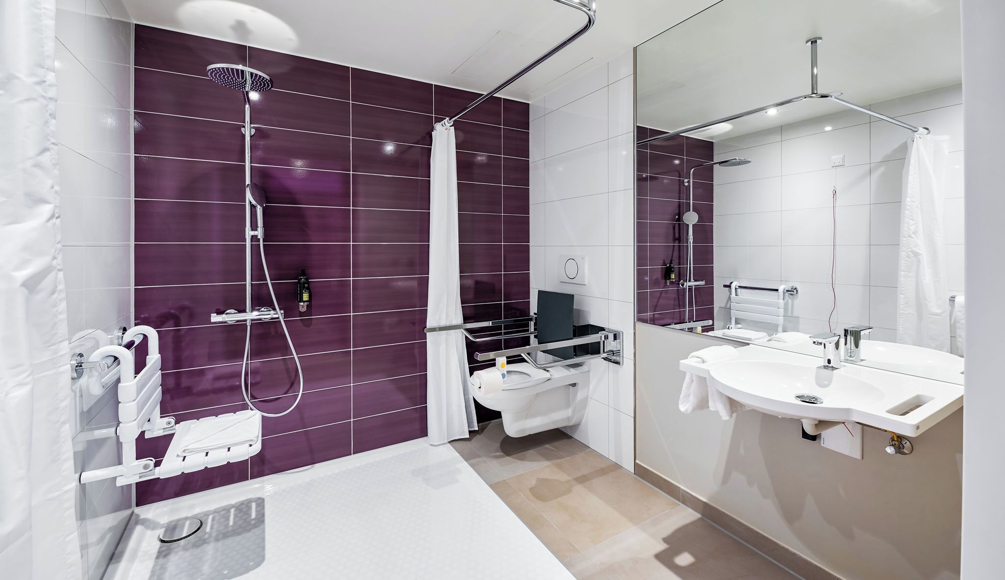 Un baño moderno con bañera, dos duchas y un espejo grande.