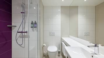 Un baño moderno con ducha, inodoro y lavamanos.
