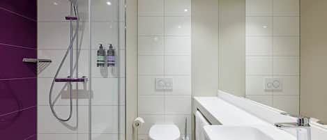 A modern bathroom with a shower, toilet, and sink.