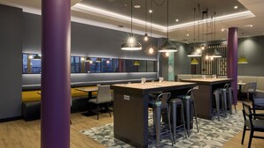 A modern restaurant with high tables, bar stools, and purple pillars. - Premier Inn Stuttgart Zuffenhausen (Stuttgart)