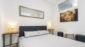 A modern hotel room with a large bed, bedside tables with lamps, a round table, and a large mirror on the wall. - Apartment 'Nr 2' with Shared Pool and Garden (Pula)