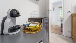 A kitchenette with a coffee maker, a basket with dishes, and a refrigerator. - Apartment 'Nr 2' with Shared Pool and Garden (Pula)