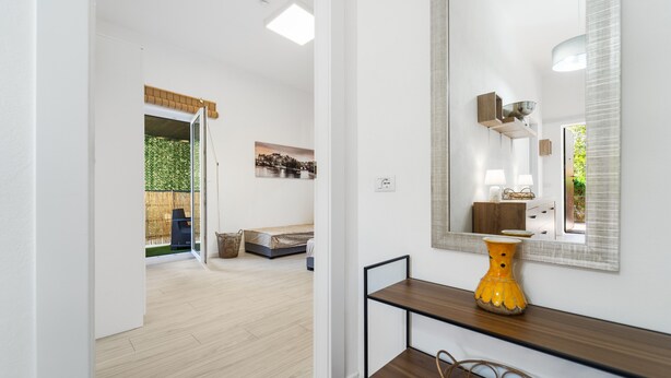A modern interior with a wooden floor, a large mirror, a yellow vase, and a wicker basket. - Apartment Nr. 3, WLAN und Klimaanlage (Pula)