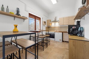 Une cuisine compacte avec des meubles en bois, un four encastré et une machine à café.