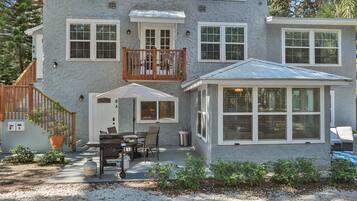 A two-story house with a balcony, a covered patio, and a small attached garage.
