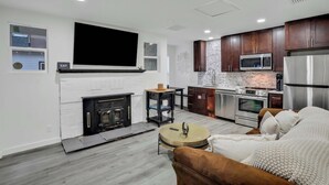 Ein modernes Wohnzimmer mit Kamin, einer Couch und einem Couchtisch.