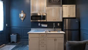 A kitchen with a central island, stainless steel appliances, and light-colored cabinetry.