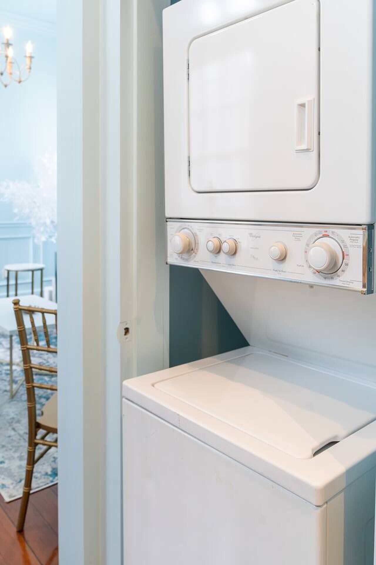 A compact, white laundry room with a front-loading washer and dryer.