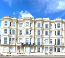 A multi-story building with bay windows and a balcony.