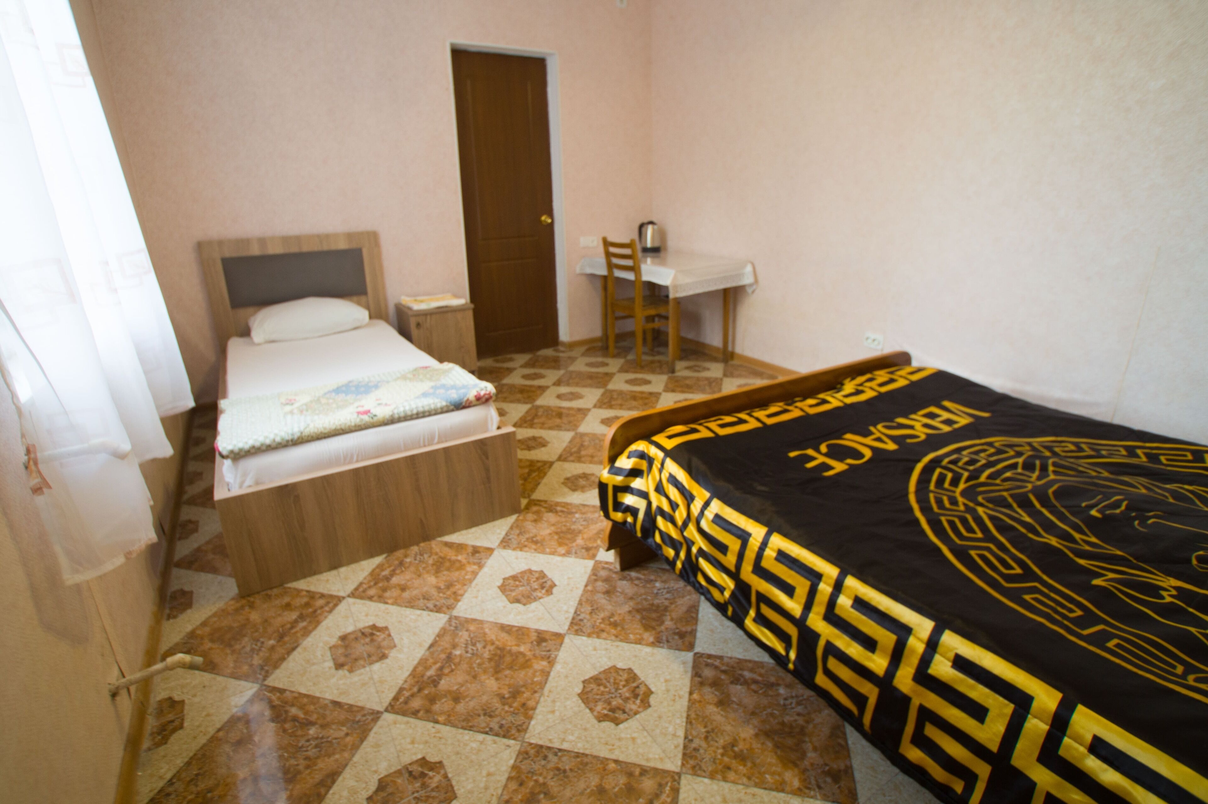Un dormitorio con una cama, un escritorio y una silla.