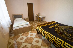Un dormitorio con una cama, un escritorio y una silla.