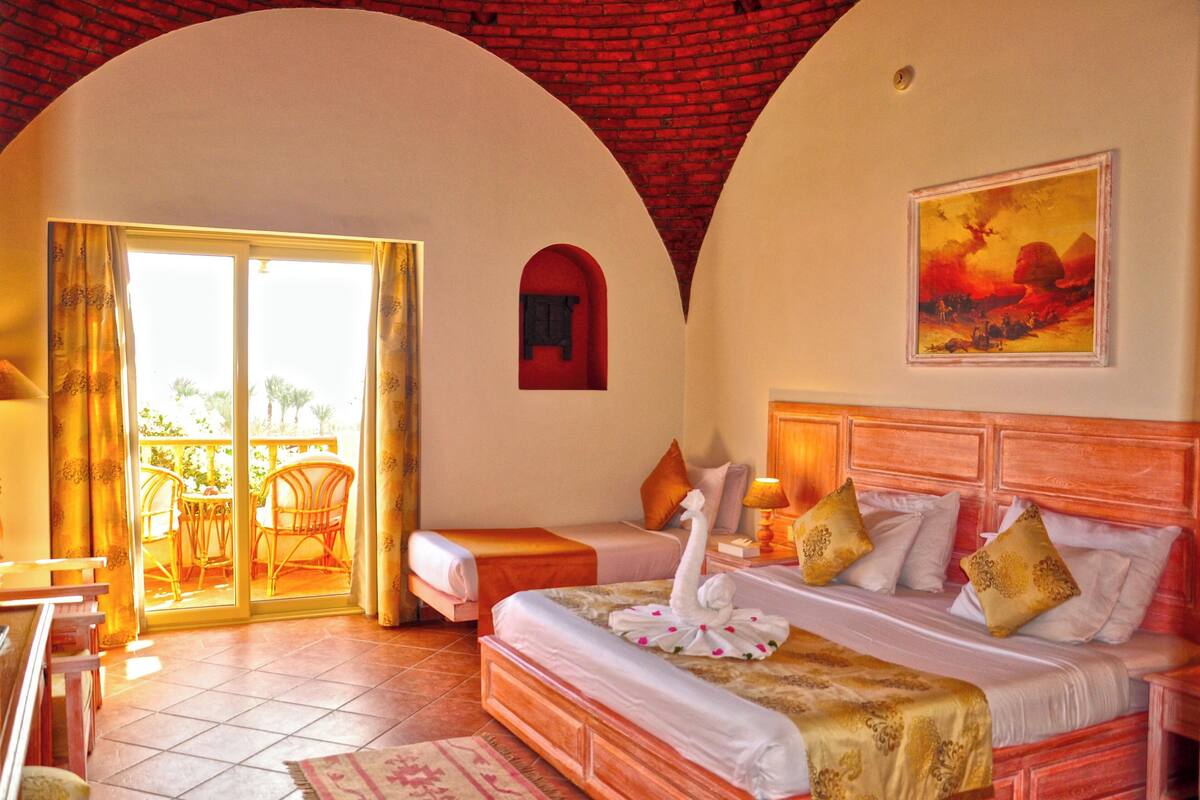Une chambre d’hôtel avec un lit, un balcon et un tableau au mur.