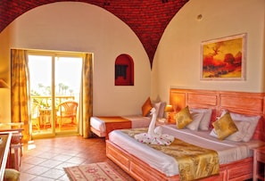 Een hotelkamer met een bed, een balkon en een schilderij aan de muur.