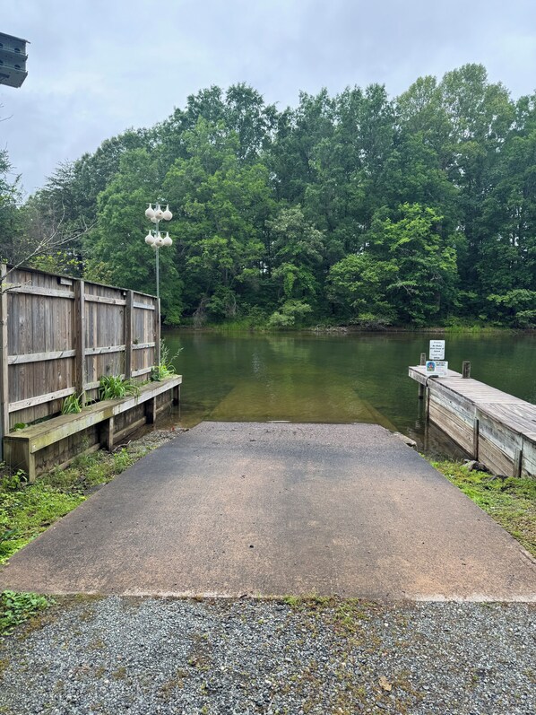 A concrete dock extending into a lake, surrounded by dense green trees. - Waterfront Lake Anna Getaway - 3BR, 2.5BA w/ Kayaks, Firepit, & Family Fun (Bumpass)