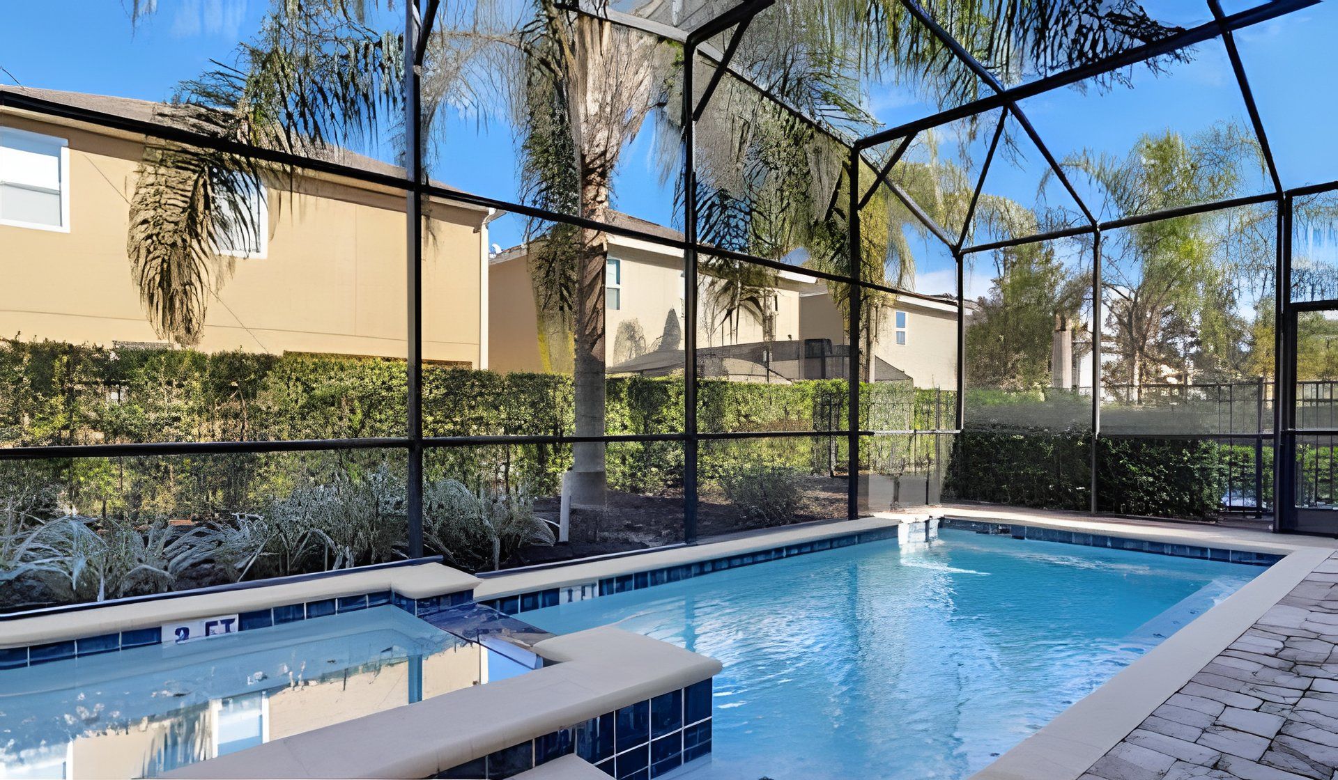 An outdoor swimming pool with a clear view of the surrounding landscape, including trees and a building in the background.