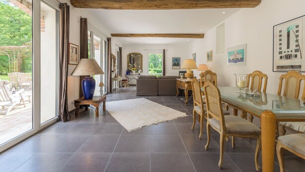 A spacious dining area with a glass table, wooden chairs, and a large window offering a view of the outdoors. - Architect-designed house for 8 people set in greenery. Near Rambouillet, Paris (Orphin)