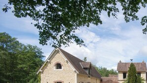 A stone building with a pitched roof, a covered porch, and a fenced yard. - Architect-designed house for 8 people set in greenery. Near Rambouillet, Paris (Orphin)