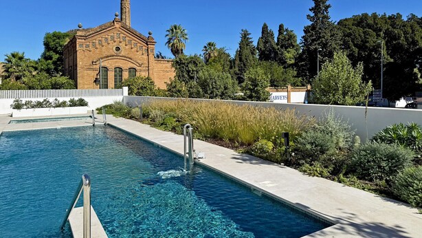 A swimming pool with a clear blue water, surrounded by a white fence and lush greenery. - La Solera de Jerez - Ole Solutions (Jerez de la Frontera)