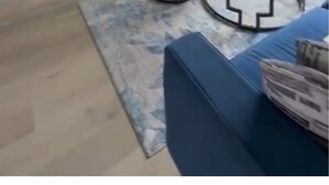 Una sala de estar con televisor, chimenea y sofá azul.
