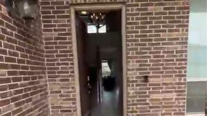 Un edificio de ladrillo con un vano central que da a un espacio interior.