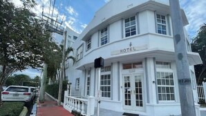 A white hotel with a sign reading "HOTEL" above the entrance. - #10 Unit in Mid-century Art-Déco Building KingBed EnSuiteBath Steps>Beach PetsOK (Miami Beach)
