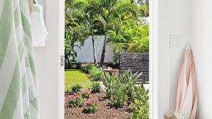 A room with a door leading to a garden with various plants and a bench. - FlipFlopsOn III • 1/2 Mile to Siesta Key • FL’s Gulf Coast • Sarasota (Sarasota)