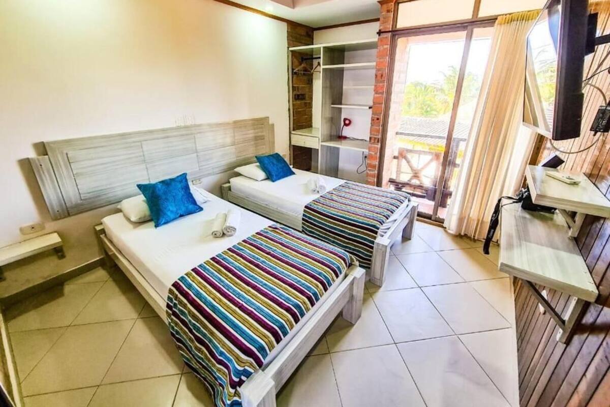 A room with two beds, a TV, and a desk.