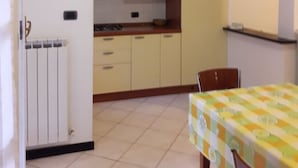 Μια μικρή κουζίνα με κίτρινα ντουλάπια, ένα φούρνο μικροκυμάτων και πλακάκι στο δάπεδο.