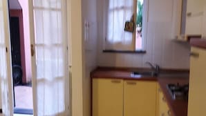 Μια κουζίνα με ένα παράθυρο, έναν νεροχύτη και ντουλάπια.