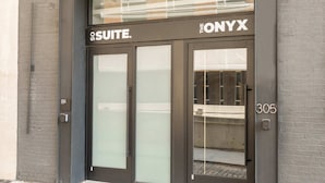 A modern building entrance with a glass door labeled "SUITE" and "THE ONYX" above. - Sosuite 1bed Apt w Roof Deck, Gym, Laundry (Philadelphia)