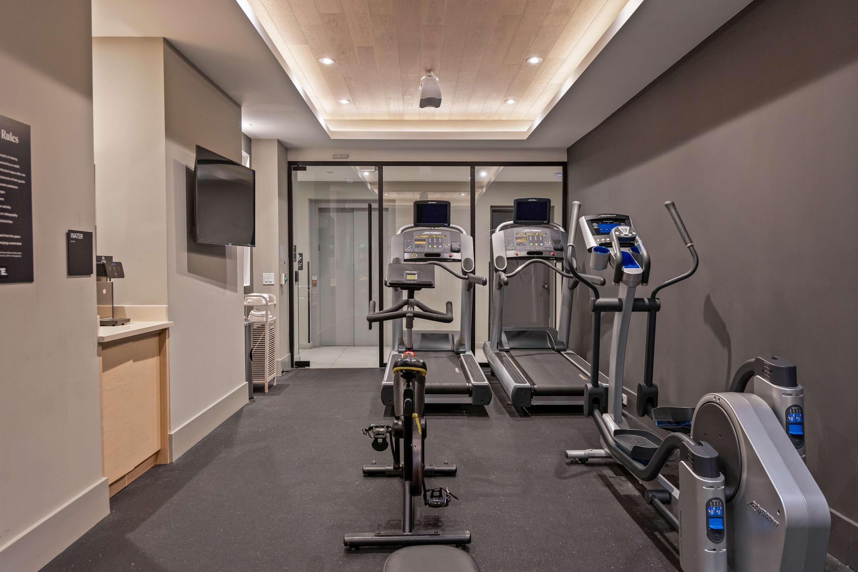 A gym with treadmills, an elliptical, and a stationary bike.
